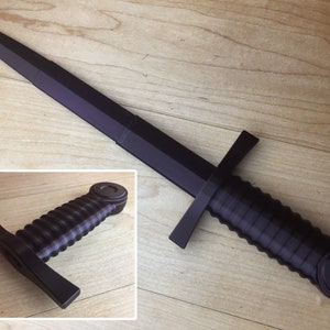 May include: A black plastic toy sword with a ribbed handle and a pointed tip.
