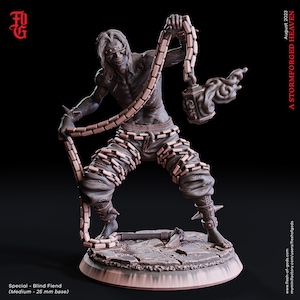 May include: A detailed miniature figurine of a blind fiend, a monstrous creature with chains wrapped around its body and a flaming chain attached to its hand. The figurine is painted in a light brown color and stands on a circular base.