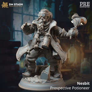 May include: A grey 3D printed miniature of a dwarf potioneer holding a flask and a burning potion. The miniature is standing on a round base with a rocky texture. The dwarf is wearing goggles, a long coat, and has a long beard. The text "Nesbit Prospective Potioneer" is printed below the miniature.