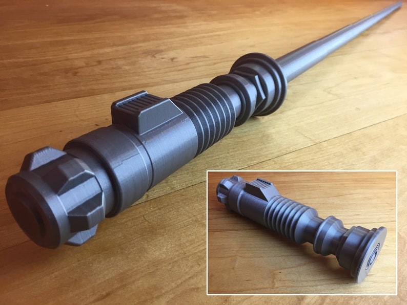 May include: A grey 3D printed lightsaber prop with a textured surface and a cylindrical design. The lightsaber is approximately 76 cm long and has a black handle.