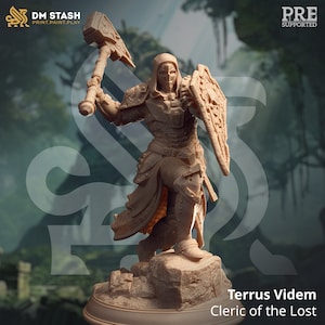 May include: A detailed miniature figurine of a cleric, wearing a hooded robe and armor, holding a hammer and shield. The figurine is painted in a light brown color and stands on a rocky base. The text "Terrus Videm Cleric of the Lost" is printed below the figurine.