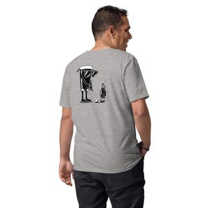 May include: A light gray t-shirt featuring a black and white graphic of a beer glass wearing sunglasses and playing golf. The design includes a golf club, ball, and golf bag. The shirt is made of a soft material.