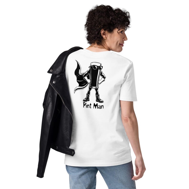 Puede incluir: Camiseta blanca con una ilustraci&oacute;n en blanco y negro de una pinta de cerveza como superh&eacute;roe, con capa y gafas de sol. El texto "Pint Man" est&aacute; debajo. Una chaqueta de cuero negra est&aacute; sobre el hombro.