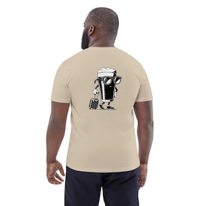 Puede incluir: Camiseta beige con un dise&ntilde;o de vaso de cerveza de dibujos animados en blanco y negro en la espalda. El vaso de cerveza lleva gafas de sol y lleva una maleta. La camiseta est&aacute; hecha de un material suave. El dise&ntilde;o es un gr&aacute;fico divertido con tem&aacute;tica de viajes.