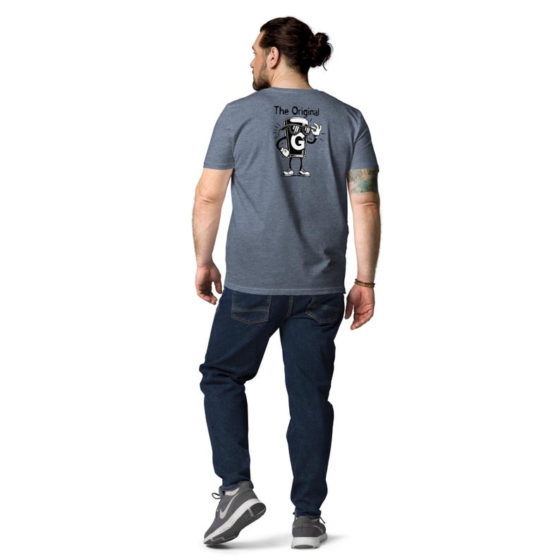May include: A blue t-shirt with a cartoon coffee cup character wearing sunglasses and the text "The Original" on the back. The person is wearing blue jeans and grey trainers.