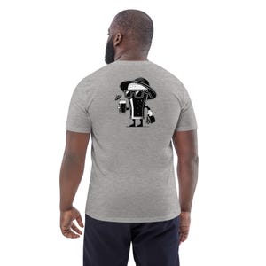 Puede incluir: Camiseta gris con una ilustraci&oacute;n de dibujos animados en blanco y negro de un vaso de cerveza con gafas de sol y un sombrero, sosteniendo una bebida con una sombrilla de c&oacute;ctel. El vaso de cerveza tambi&eacute;n lleva un bolso.