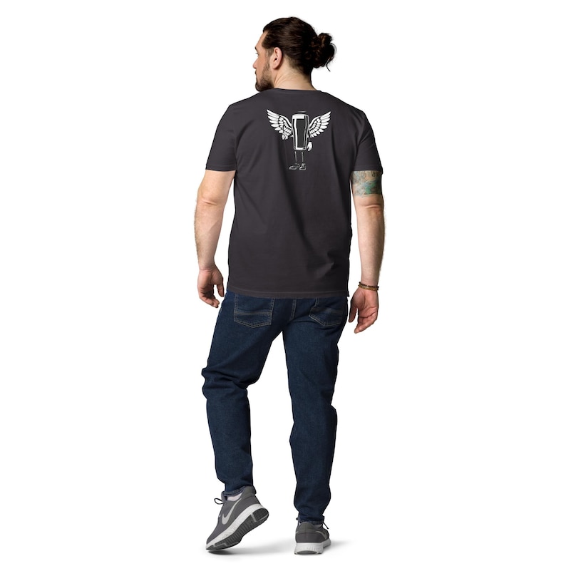 May include: Dark gray t-shirt with a white graphic of a winged object. The person is wearing blue jeans and gray sneakers. The graphic is on the back of the shirt.