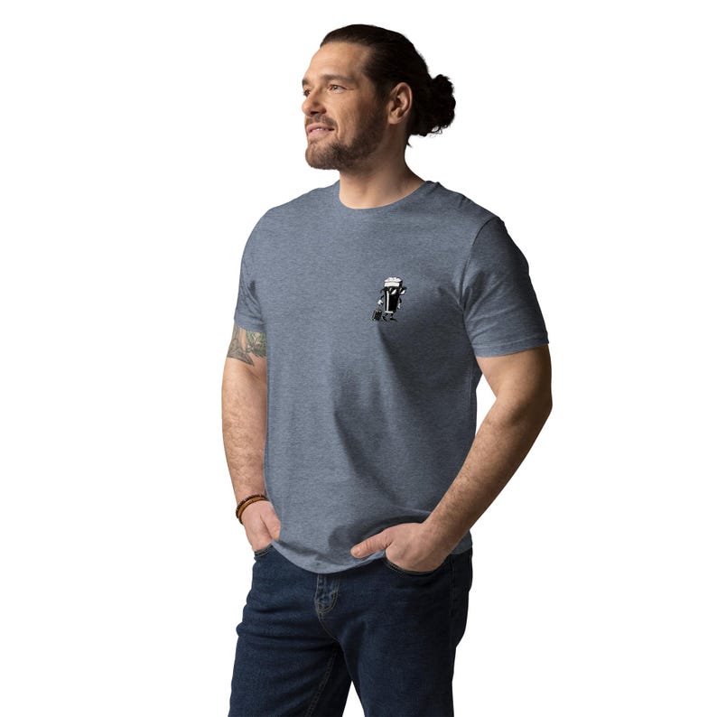 Puede incluir: Camiseta azul jaspeado de manga corta con un peque&ntilde;o gr&aacute;fico en blanco y negro en el pecho. El gr&aacute;fico es una ilustraci&oacute;n estilizada. La camiseta es de material suave.