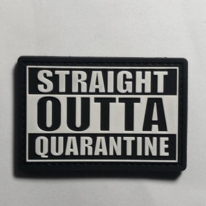 May include: A rectangular black and white patch with the words "STRAIGHT OUTTA QUARANTINE" in bold, capital letters. The text is arranged in three lines, with "OUTTA" in a white rectangle.