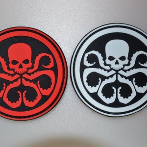 May include: Two round patches featuring a skull with tentacles. One patch has a red skull and tentacles on a black background, surrounded by a red border. The other has a white skull and tentacles on a black background, with a white border.