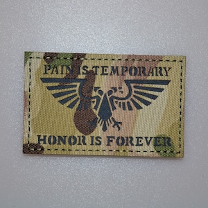 Op de afbeelding: Rechthoekige patch met een camouflagepatroon achtergrond. De patch heeft de tekst "PAIN IS TEMPORARY" erboven en "HONOR IS FOREVER" eronder, met een zwart embleem van een vogel met uitgespreide vleugels.