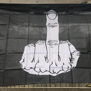 Peut inclure: Drapeau noir avec un grand dessin blanc d'une main faisant un geste obscène. Le drapeau a une bordure blanche et des œillets pour l'accrocher. Design audacieux et provocateur.