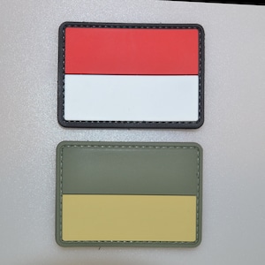 May include: Two rectangular patches. The top patch features the Indonesian flag: a red over white horizontal bicolor, with a black border. The bottom patch has a green over yellow horizontal bicolor, with a green border.