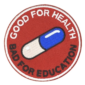 Könnte beinhalten: Runder, gestickter Aufnäher mit rotem Hintergrund und weißem Rand. Der Aufnäher zeigt den Text "GOOD FOR HEALTH" und "BAD FOR EDUCATION" in Weiß, der eine blau-weiße Kapsel umschließt.