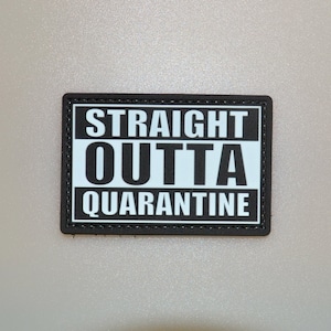 May include: A rectangular black and white patch with the words "STRAIGHT OUTTA QUARANTINE" in bold, sans-serif font. The text is centered on a white background, framed by a black border.