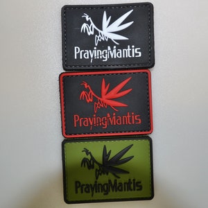 May include: Three rectangular patches featuring a mantis design and the words "Praying Mantis". The top patch is black with a white mantis and text. The middle patch is black with a red mantis and text. The bottom patch is olive green with a black mantis and text.