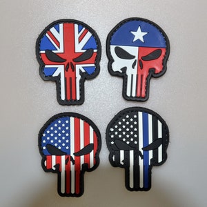 May include: Four skull-shaped patches with black borders. Two feature the American flag design, one with a blue line. The other two have the Union Jack and Texas flag designs, respectively. Each patch has a black skull outline.