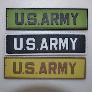 May include: Three rectangular patches with the text "U.S. ARMY". The top patch is olive green with black lettering, the middle is black with white lettering, and the bottom is tan with brown lettering. The patches have a textured appearance.