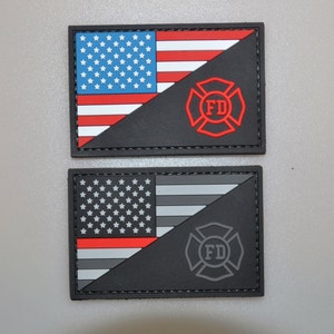 Puede incluir: Dos parches rectangulares. El parche superior presenta la bandera estadounidense en la parte superior izquierda y un emblema FD rojo sobre un fondo negro. El parche inferior tiene una bandera estadounidense en blanco y negro con una franja roja y un emblema FD gris.