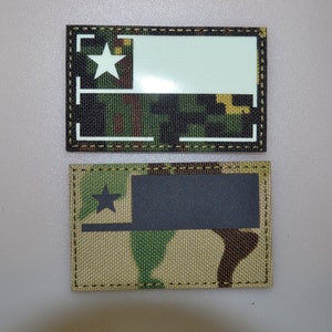 May include: Two rectangular patches. The top patch has a camouflage pattern with a white star and a white rectangle. The bottom patch has a camouflage pattern with a black star and a black rectangle. Both patches have a black border.