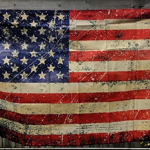Könnte beinhalten: Eine verwitterte amerikanische Flagge mit roten und weißen Streifen und einem blauen Sternenfeld. Die Flagge hat ein Vintage-Aussehen mit verblassten Farben und einer strukturierten Oberfläche, als wäre sie dem Wetter ausgesetzt gewesen.