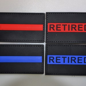 May include: Four black rectangular patches with stitched edges. Two have a red stripe or the word "RETIRED" in red. The other two have a blue stripe or the word "RETIRED" in blue. Patches are likely for uniforms.