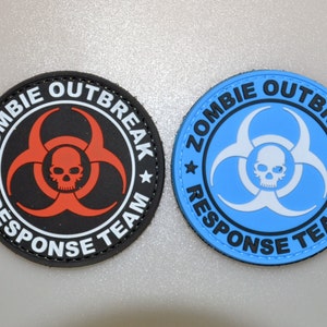 Puede incluir: Dos parches redondos con el texto "ZOMBIE OUTBREAK RESPONSE TEAM". Uno es negro con un símbolo de peligro biológico y una calavera rojos. El otro es azul claro con un símbolo de peligro biológico y una calavera blancos.