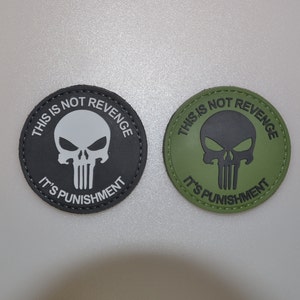 Könnte beinhalten: Zwei runde Aufnäher mit dem Text "THIS IS NOT REVENGE IT'S PUNISHMENT" und einer Totenkopf-Grafik. Ein Aufnäher ist schwarz mit einem weißen Totenkopf, der andere olivgrün mit einem schwarzen Totenkopf.