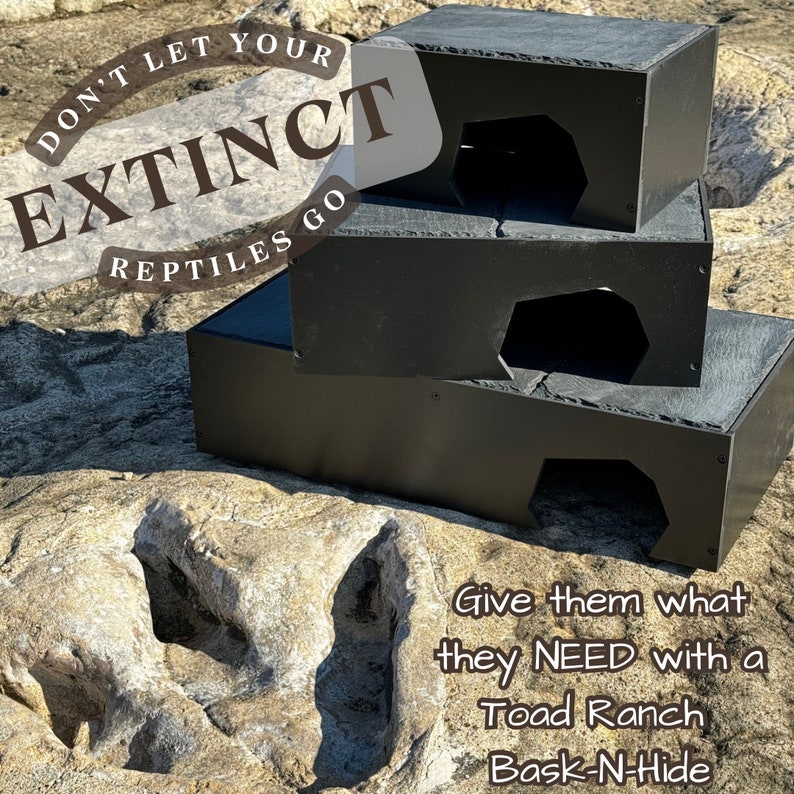 K&ouml;nnte beinhalten: Drei schwarze Schiefer-Reptilienverstecke, die &uuml;bereinander gestapelt sind. Die Verstecke haben eine gro&szlig;e &Ouml;ffnung auf einer Seite. Der Text "Don't Let Your Reptiles Go Extinct" befindet sich in einem Kreis oben im Bild. Der Text "Give them what they NEED with a Toad Ranch Bask-N-Hide" befindet sich unten im Bild.
