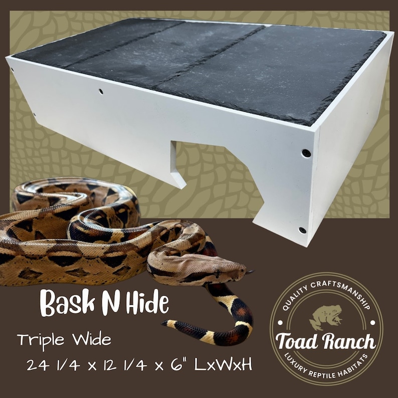 K&ouml;nnte beinhalten: Wei&szlig;es Reptilienversteck mit schwarzer Schieferplatte. Das Versteck ist 61,6 cm lang, 31,1 cm breit und 15,2 cm hoch. Der Text "Bask N Hide Triple Wide" ist auf der Vorderseite des Verstecks aufgedruckt.