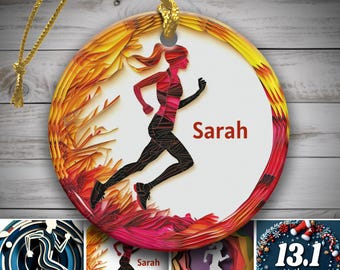 Könnte beinhalten: Runder Keramikschmuck mit einer laufenden Figur in Rot und Schwarz, mit dem Namen "Sarah" in Rot. Der Schmuck hat eine goldene Aufhängeschnur und ein geschichtetes Blumendesign in Gelb-, Orange- und Rottönen.