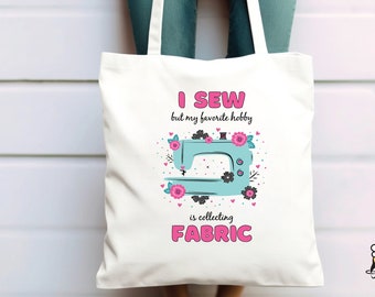 May include: White tote bag with a pink and blue sewing machine design. The text on the bag reads "I sew but my favorite hobby is collecting fabric".