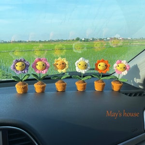 Peut inclure: Six ornements de pot de fleurs en crochet dans une voiture. Les fleurs sont jaunes, orange, blanches, roses et violettes. Les pots sont bruns. Le texte "May's house" est visible dans le coin inférieur droit de l'image.