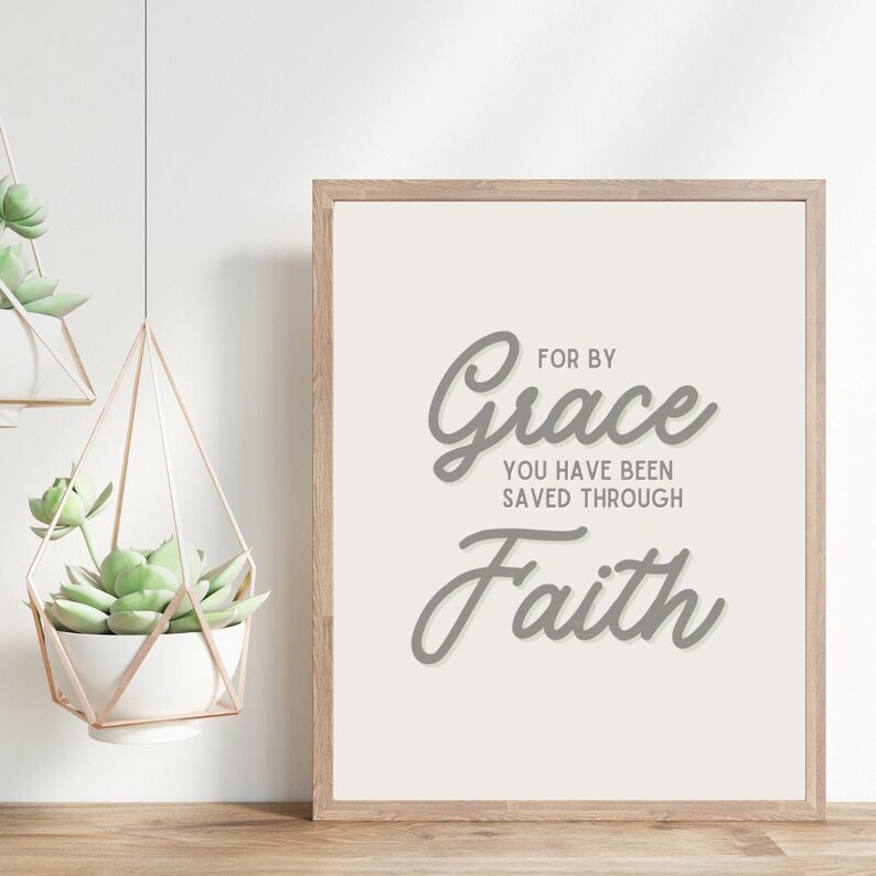 May include: A framed print with a white background and gray text that reads "For by Grace you have been saved through Faith".