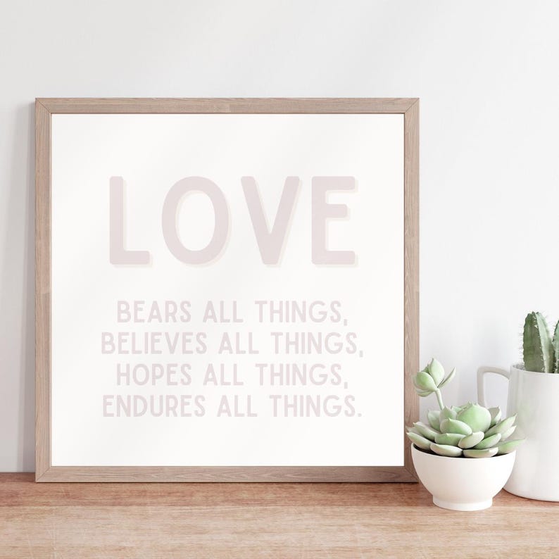 May include: A framed print with the word "LOVE" in large, pink letters. The text below reads "Bears all things, Believes all things, Hopes all things, Endures all things."