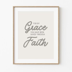 May include: A framed print with a white background and gray text that reads "For by Grace you have been saved through Faith".