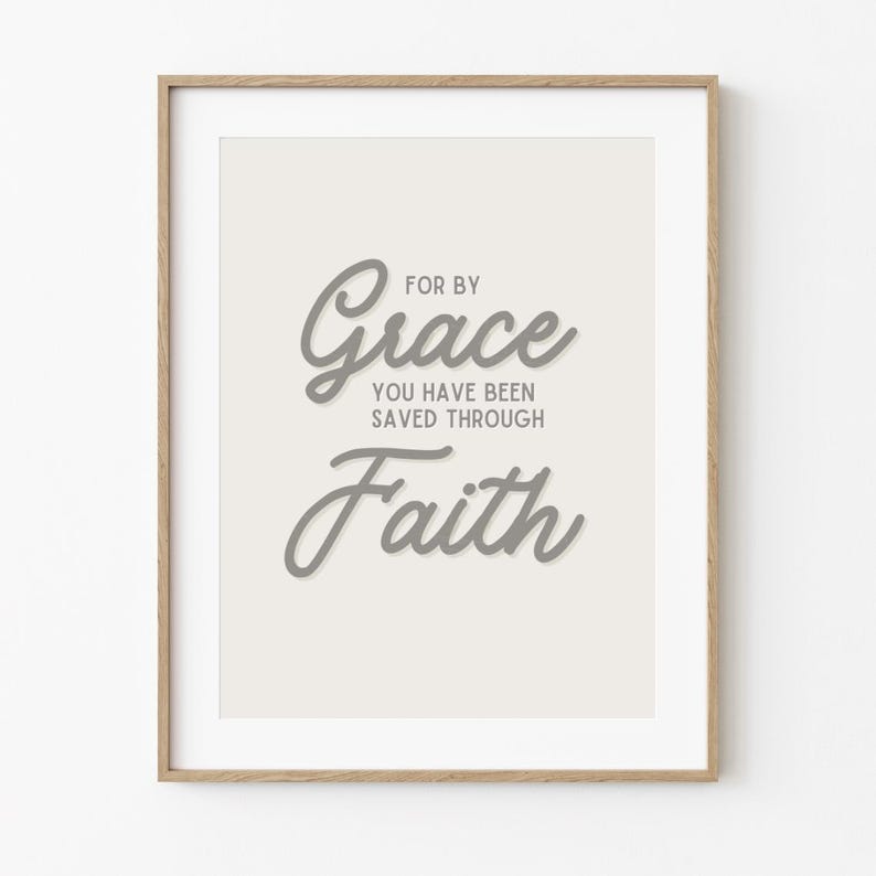 May include: A framed print with a white background and gray text that reads "For by Grace you have been saved through Faith".