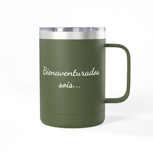 May include: An olive green insulated mug with a handle and a silver-colored lid. The mug features the white text "Bienaventurados sois..." printed on the front. The exterior has a matte finish and a cylindrical shape with a flat base.