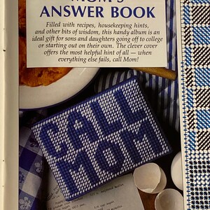 May include: A blue and white needlepoint project with the words "Call Mom" stitched in white. The project is sitting on a white and blue checkered fabric. The text "Please read General Instructions, pages 29-30, before beginning project." is printed below the project.