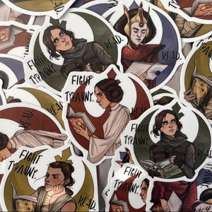 Könnte beinhalten: Eine Sammlung runder Aufkleber mit Illustrationen von Charakteren, die Bücher lesen. Die Aufkleber haben einen weißen Rand und enthalten die Sätze "FIGHT TYRANNY" und "READ". Die Farbpalette umfasst Rot, Grün und Braun.