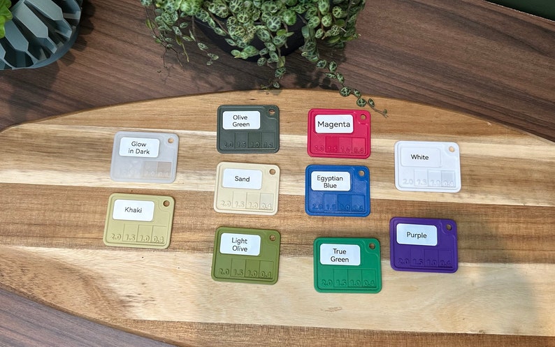 May include: A set of ten color swatches, each with a different color and a label. The colors include: Olive Green, Magenta, Glow in Dark, Khaki, Sand, Egyptian Blue, White, Purple, Light Olive, and True Green.