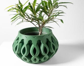 Puede incluir: Un macetero de cerámica verde con un diseño geométrico intrincado. El macetero tiene forma de jarrón con una abertura ancha y una base estrecha. El diseño presenta una serie de formas curvas superpuestas que crean un patrón visualmente interesante.