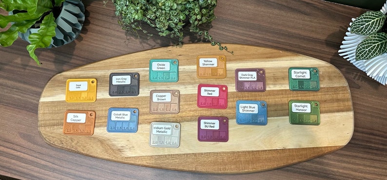 May include: A wooden board with 14 small square color samples. The samples are labeled with names like "Copper Brown", "Yellow Shimmer", and "Cobalt Blue Metallic".
