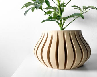 May include: A light brown, ribbed, ceramic planter with a plant growing out of it. The plant has green leaves and a brown stem.