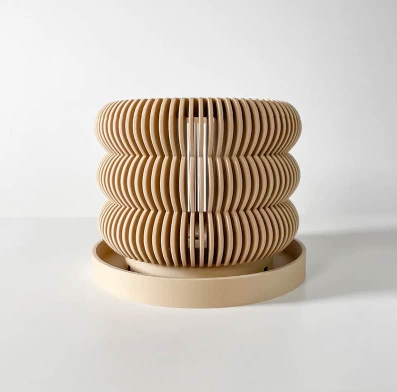 May include: A beige, wooden planter with a unique, wavy design. The planter has a removable base and is perfect for displaying plants or flowers.