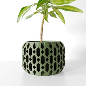 May include: A green planter with a geometric pattern. The planter is made of a durable material and has a modern design.