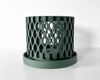 May include: A dark green planter with a hexagonal pattern. The planter has a removable base.