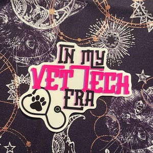 May include: A pink and white sticker with the text "In my Vet Tech Era" and a black paw print inside a stethoscope.
