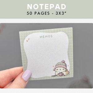 May include: A notepad with 50 pages, measuring 3x3 inches, features a cute cartoon animal wearing a hat and holding yarn. The notepad has a green grid pattern and the words "MEMOS" are printed at the top.