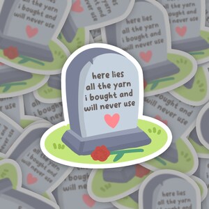 Könnte beinhalten: Ein Aufkleber mit einem Grabstein, auf dem der Text "Hier liegt all die Wolle, die ich gekauft habe und nie verwenden werde" steht. Der Grabstein ist grau mit einem rosa Herzen darauf. Vor dem Grabstein liegt eine rote Rose auf dem Boden.